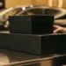 Elegante schwarze Geschenkboxen für Automotiv-Produkte gestapelt auf poliertem Showroom-Tresen mit goldener Beleuchtung