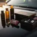 Elegante Automotive-Geschenkartikel auf glänzender schwarzer Motorhaube bei goldenem Sonnenlicht arrangiert