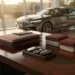 Mahagoni-Schreibtisch im Autohaus-Showroom mit Premium-Kundengeschenken wie Lederportfolios und Schlüsselanhängern, Luxuslimousine im Hintergrund