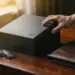 Schwarze matte Geschenkbox auf Mahagoni-Schreibtisch neben Autoschlüsseln und Lederportfolio bei warmem Licht