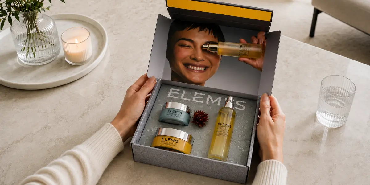 Hände halten eine offene Beauty Box von Elemis mit Creme und spray Produkten im Inlay