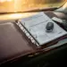 Leder-Ringordner mit Fahrzeugwartungsdokumenten auf Armaturenbrett, Autoschlüssel und Zulassungspapiere daneben