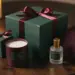 Elegantes Firmen-Weihnachtsgeschenkset mit Satinschleife, Kerze, Schal und Flasche auf dunklem Walnussholz in Grün, Burgund und Gold.
