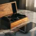Geöffnete Holzgeschenkbox aus Nussbaum mit Samtfutter neben Smartphone auf Marmoroberfläche bei warmem Licht