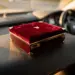 Luxuriöse Geschenkbox mit burgunderrotem Samt und goldenen Akzenten auf Lederdashboard eines Autos im warmen Morgenlicht