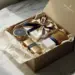 Geöffnete Luxus-Geschenkbox mit Beauty-Produkten in cremefarbenem Seidenpapier auf Marmoroberfläche in Gold- und Marinetönen.