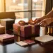 Luxuriöse Geschenkbox mit eleganter Schleife auf poliertem Holzkonferenztisch, umgeben von Premium-Produktproben im warmen Nachmittagslicht