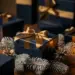 Luxuriöse Geschenkbox mit Schleife auf Tannenzweigen, umgeben von eleganten Corporate-Geschenkpaketen in Navy und Gold bei Kerzenlicht.