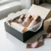 Geöffnete Luxus-Geschenkbox mit elegant verpackten Kosmetikprodukten in Seidenpapier, Roségold- und Cremetönen, natürliches Seitenlicht.