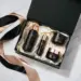Mattschwarze Geschenkbox mit Luxus-Kosmetikprodukten in Seidenpapier auf Marmoroberfläche, Draufsicht im Flat-Lay-Stil.