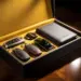 Luxuriöse schwarze Geschenkbox mit goldener Innenauskleidung auf Mahagoni-Oberfläche, gefüllt mit Leder-Schlüsselanhängern und Auto-Accessoires