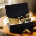 Luxuriöse navy-blaue Geschenkbox mit goldenem Band, gefüllt mit hochwertigen Corporate Gifts in Seidenpapier auf Eichenholz.