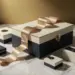 Luxuriöse Geschenkbox mit Premiumband auf weißem Marmor, umgeben von Verpackungsmustern in Creme und Marineblau mit Goldakzenten.