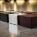 Elegante Geschenkboxen in Premium-Autofarben mit matten, metallischen und Leder-Oberflächen auf glänzendem Showroom-Boden