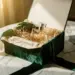 Luxuriöse Influencer-Box mit Seidenpapier, Glasparfümflakon und Samtband auf Marmor im warmen Gegenlicht.