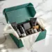 Luxuriöse grüne PR-Box mit Premium-Lifestyle-Produkten in schwarzen Schaumstoff-Einsätzen auf weißem Studiotisch
