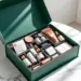 Luxuriöse smaragdgrüne PR-Box mit Goldakzenten enthält Premium-Lifestyle-Produkte auf weißem Marmortisch