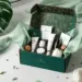 Luxuriöse smaragdgrüne PR-Box mit Goldakzenten zeigt Tech-Gadgets, Kaffee-Pods und Wellness-Produkte in schwarzem Schaumstoff