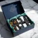 Offene marineblaue PR-Box mit Goldakzenten auf Marmortisch, gefüllt mit Premium-Lifestyle-Produkten in Schaumstoff