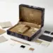 Luxuriöse PR-Box mit Samtinterieur, Produktmuster, Pantone-Farbchips und Materialmustern auf weißer Studiofläche.