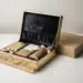 Luxuriöse Press-Kit-Box mit Samtinterieur, Produktproben und Markengewebe neben einem schlichten Karton auf weißer Oberfläche.