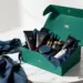 Luxuriöse smaragdgrüne PR-Box mit Premium-Lifestyle-Produkten auf weißem Marmortisch, professionelle Studiofotografie