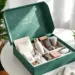 Luxuriöse grüne PR-Box mit Premium-Produkten wie Kaffee, Schokolade, Wasserflasche und Kopfhörern auf weißem Tisch