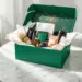Luxuriöse grüne PR-Box mit Goldakzenten enthält Hautpflege, Tech-Zubehör und Premium-Artikel auf Marmortisch