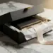Mattschwarze Premium-Geschenkbox mit Seidenpapier und Goldband auf Marmoroberfläche, sanftes Studiolicht.
