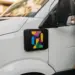 Schwarze Magnetbox mit Firmenbranding an weißem Lieferwagen befestigt, urbane Straßenszene bei Tageslicht