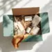 Offene Premium-Kartonbox aus Kraftpapier mit nachhaltigen Öko-Produkten wie Bambuszahnbürste und Glasflaschen
