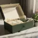 Offene Premium-Geschenkbox mit matter Oberfläche auf Marmor, Produktproben in Seidenpapier und kleiner grüner Setzling im Vordergrund.