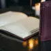 Aufgeschlagene Ledermappe auf poliertem Restauranttisch im Kerzenlicht, cremeweiße Seiten und burgunderrotes Einband-Detail.