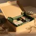 Offene Kraft-Onboarding-Box mit moosgrünem Seidenpapier, getrocknetem Eukalyptus und Recycling-Bindfaden auf hellem Eichenholz.