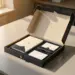 Geöffnete Onboarding-Box mit gebrandeten Artikeln wie Notizbuch, Stift und Willkommenskarte auf modernem Schreibtisch in warmem Licht.