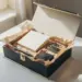 Geöffnete Onboarding-Box mit Willkommensgeschenken, Grußkarte und Seidenpapier in Champagner- und Goldtönen auf weißem Schreibtisch.