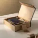 Premium-Onboarding-Willkommensbox geöffnet auf weißem Schreibtisch mit Notizbuch, Stift und Geschenken in Seidenpapier, Champagner- und Marineblauntönen.