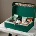 Luxuriöse grüne PR-Geschenkbox mit Roségold-Akzenten, gefüllt mit Schokolade und Kaffee auf Marmortisch