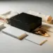 Aufgeklapptes Press-Kit mit mattschwarzem Produktkarton, elfenbeinfarbenem Seidenpapier und gebürsteten Goldakzenten auf weißer Oberfläche.