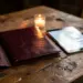 Aufgeschlagene Ledergebundene Speisekarte in Burgunderrot neben einem digitalen Tablet-Menü auf rustikalem Holztisch, Kerzenlicht.