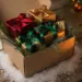 Weihnachtsgeschenkbox mit Schleifen, Tannenzweigen und edlen Päckchen auf verschneitem Holz, warmes Kerzenlicht, Rot-Gold-Grün-Töne.