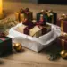 Elegante Geschenkbox mit Satinschleife in weißem Seidenpapier, umgeben von Paketen, Tannenzweigen und goldenen Weihnachtskugeln im Kerzenlicht.