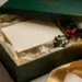 Luxuriöse Weihnachts-Geschenkbox mit handgeschriebener Karte, Stechpalmenzweigen und goldener Schleife in cremefarbenem Seidenpapier.